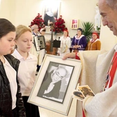 Dzieci ze szkoły w Łękawce w procesji z darami przynoszą zdjęcia ks. Jana Marszałka.