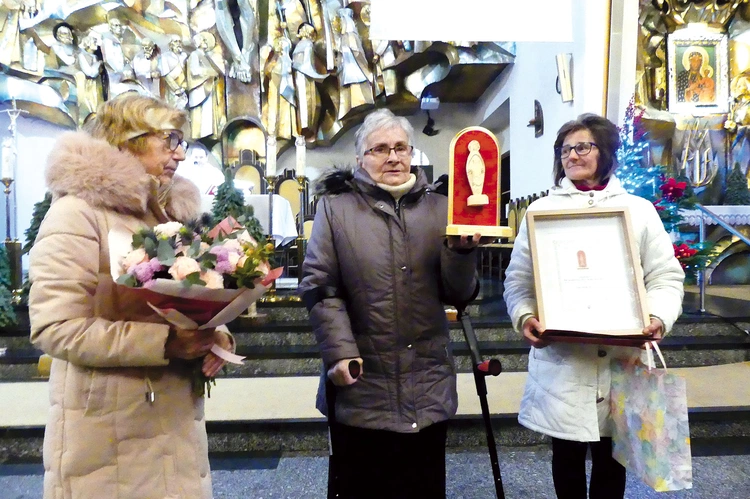Laureatka (w środku) ze statuetką „Matki Bożej zza drutów”.