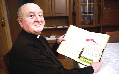 Ks. Stanisław Biskup z kroniką, której pisanie rozpoczął ks. Karol Suwada.