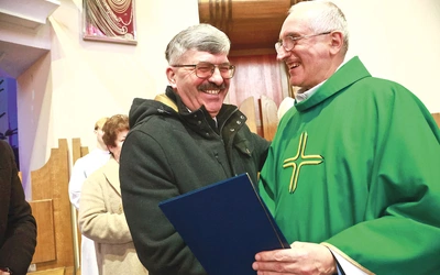 Julian Kozioł odbiera dyplom z rąk o. Ryszarda Żubera OFM.