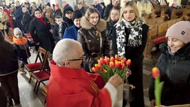 Ks. Mucha rozdaje tulipany, symbol prawdziwej miłości.