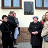 Krewni Augustynów i samorządowcy przed  odsłoniętą tablicą.
