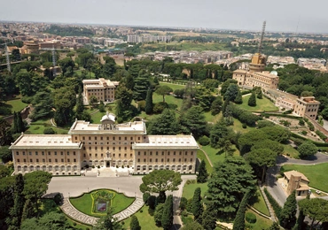 Okazały pałac widoczny na pierwszym planie jest siedzibą Gubernatoratu Państwa Watykańskiego, który zajmuje się administrowaniem Watykanem. Przed budynkiem znajduje się wykonany z kwiatów herb aktualnego papieża.