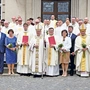 Nowo wyświęceni w otoczeniu rodziców, biskupów i księży. 