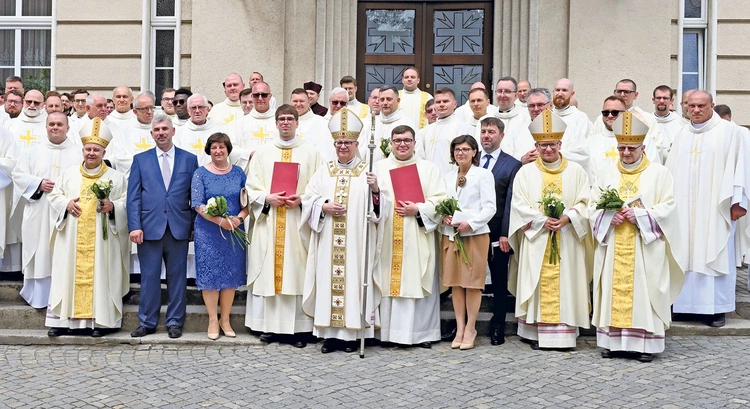 Nowo wyświęceni w otoczeniu rodziców, biskupów i księży. 